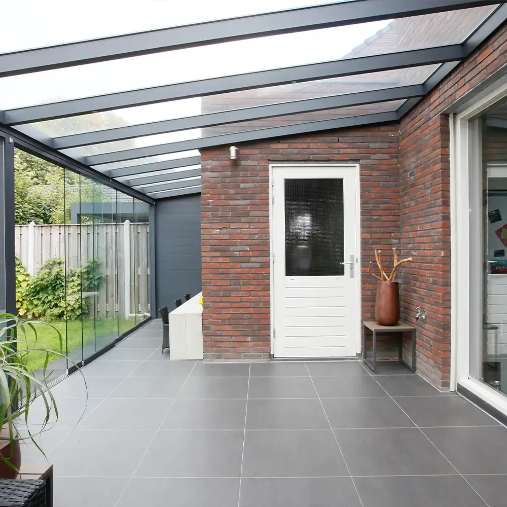 Veranda met glazen dak en antraciet profielen van AluSolutions