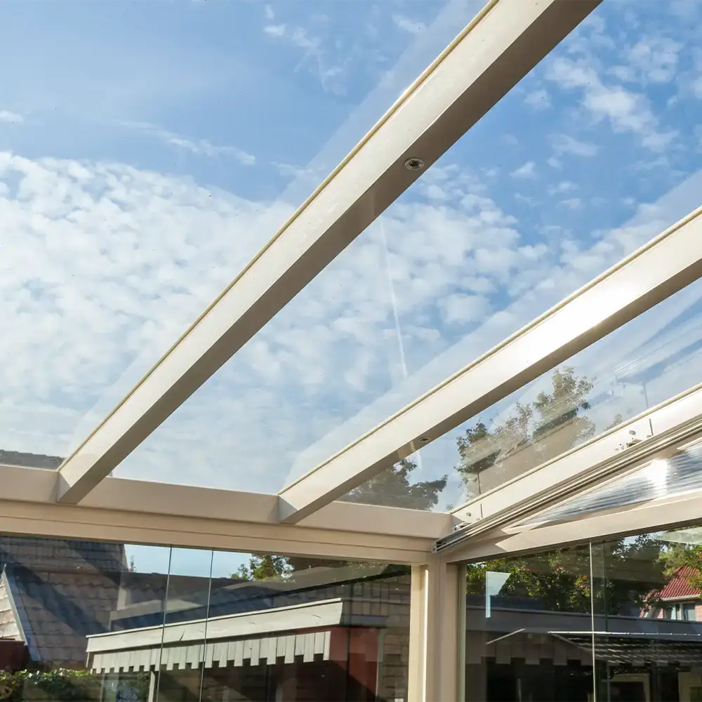 Moderne tuinkamer met glazen dak en zwart kader geplaatst door Alu Solution