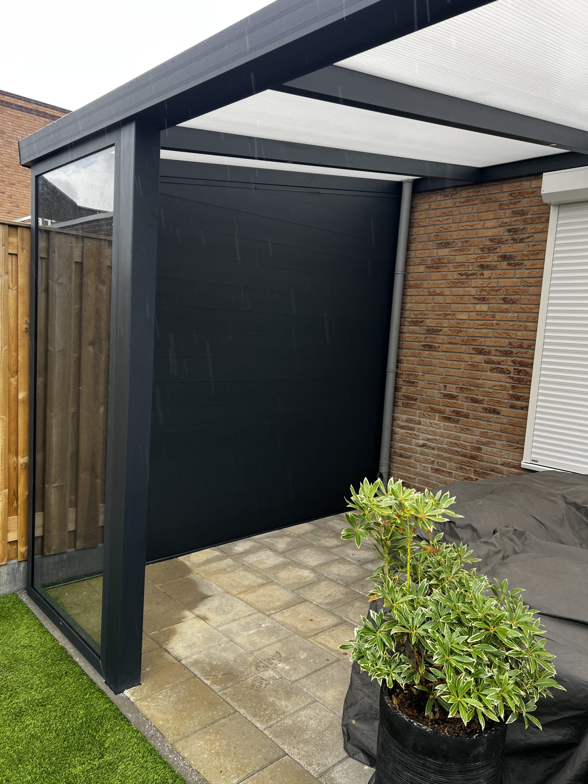 Veranda met glazen schuifwand in de avond geplaatst door AluSolutions