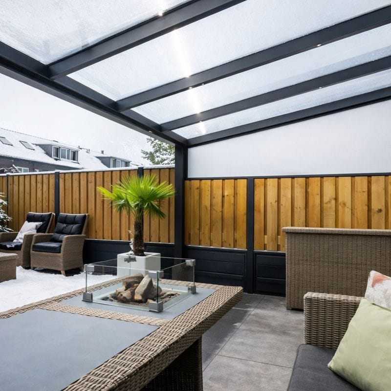 Winterklare veranda met glazen schuifwanden, beschermd tegen kou en sneeuw voor comfortabel buitenleven