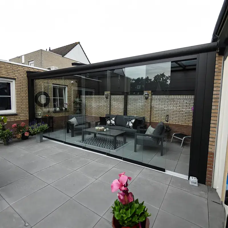 Glazen veranda met zicht op een weelderige tuin en strak design geplaatst door Alu Solution