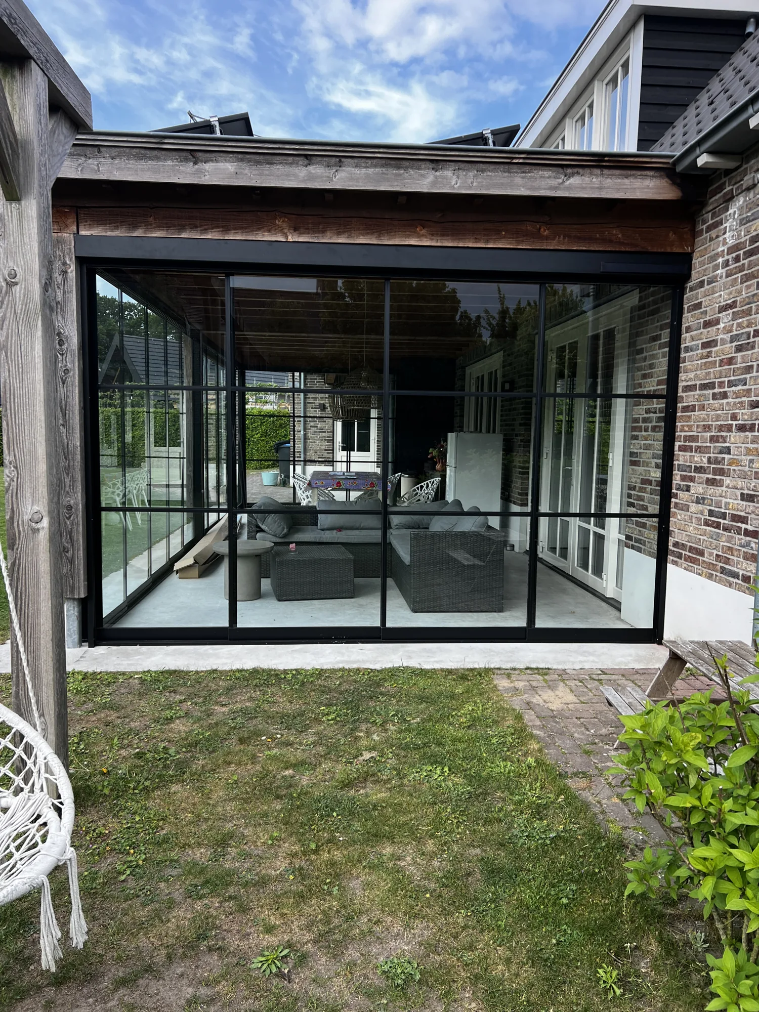 Glazen tuinkamer met schuifwanden aan een hoekwoning, geplaatst door AluSolutions